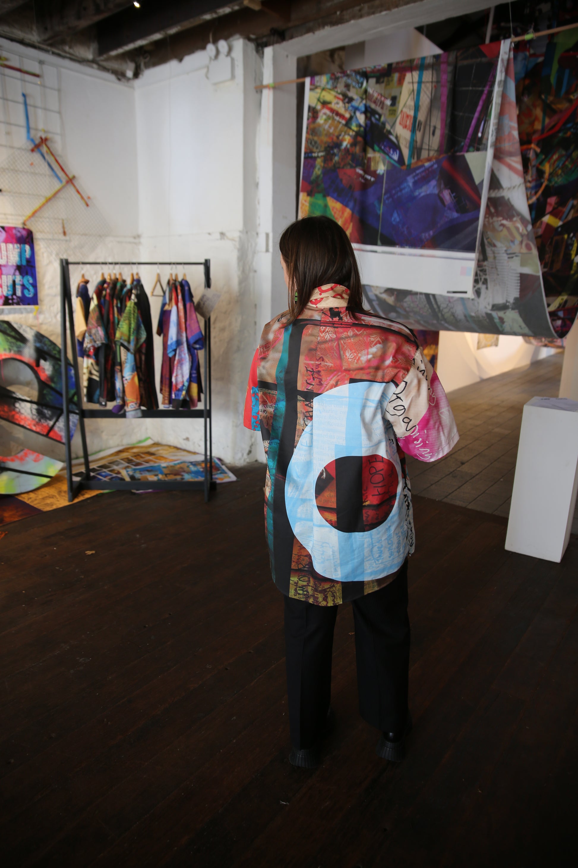 Person standing in a room with colorful printed fabric
