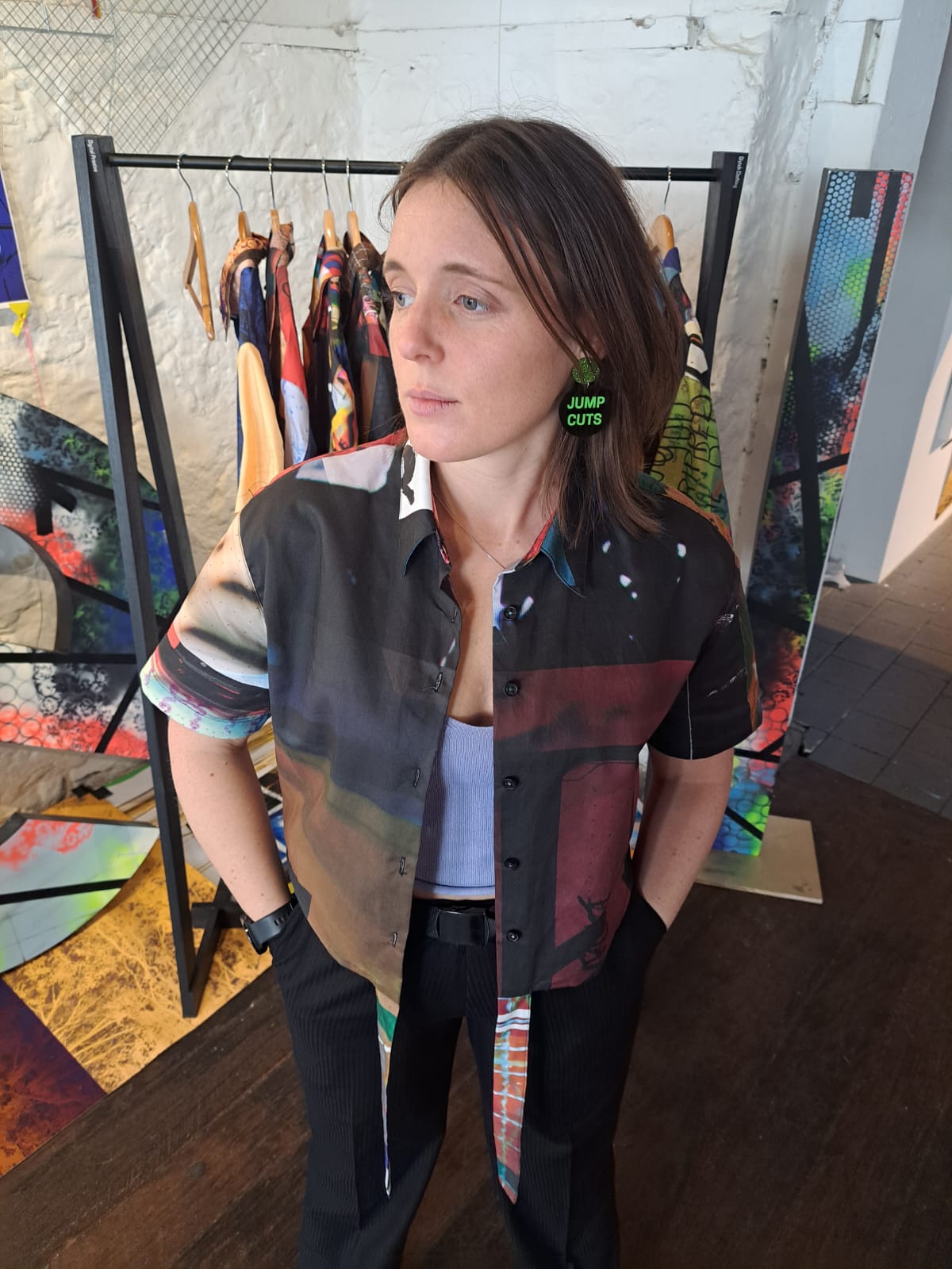 Person wearing a colorful crop shirt shirt with abstract patterns in a gallery setting