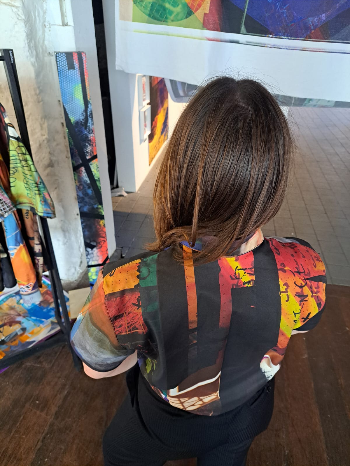 Person wearing a colorful crop shirt in an art gallery setting